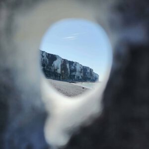 Steilküste fotografiert durch das Loch in einem Hühnergott