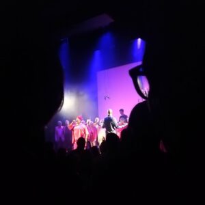 aus dem Publikum durch die vor mir sitzenden Gäste die Bühne geknipst - Auftritt des "Heaven can wait"-Chors