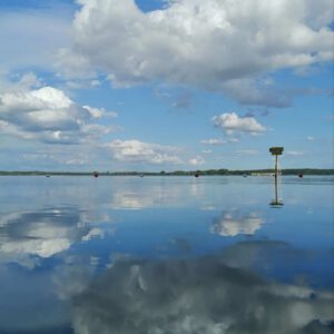 spiegelnder See mit Wolken und blauem Himmel