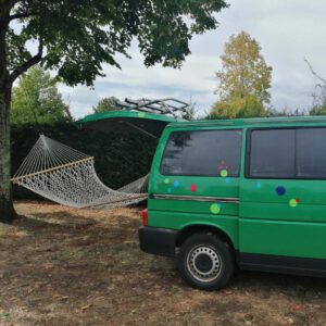 Der Konfettibus parkend in Frankreich mit Hängematte von Heck zu Baum