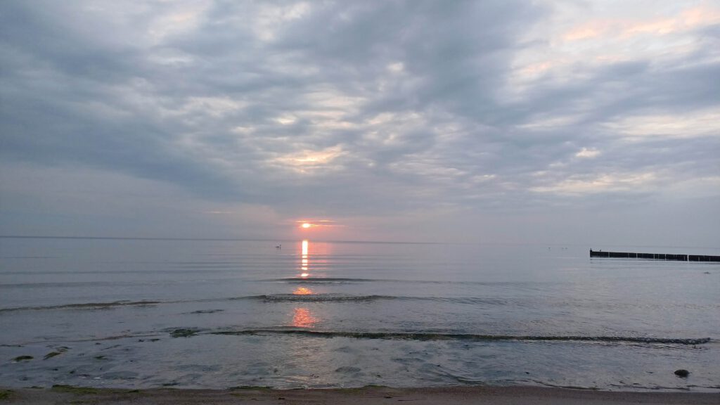 Blick auf die Ostsee bei einer Morgenmeditation im Sonnenaufgangslicht