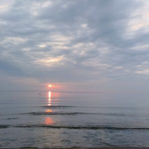 Meditieren im Sonnenaufgang am Ostseestrand