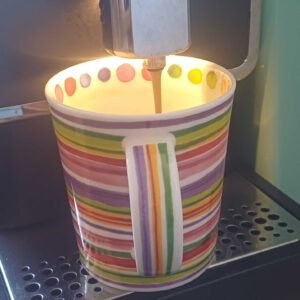 Kaffeebecher mit bunten Streifen am Kaffeevollautomaten